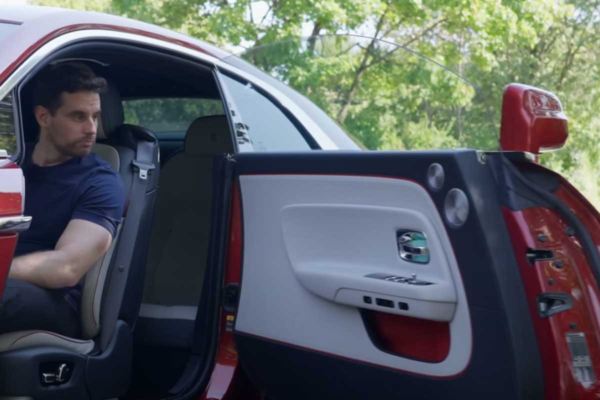 Daniel Hohmeyer sitzt im Rolls Royce Spectre und die Tür ist auf